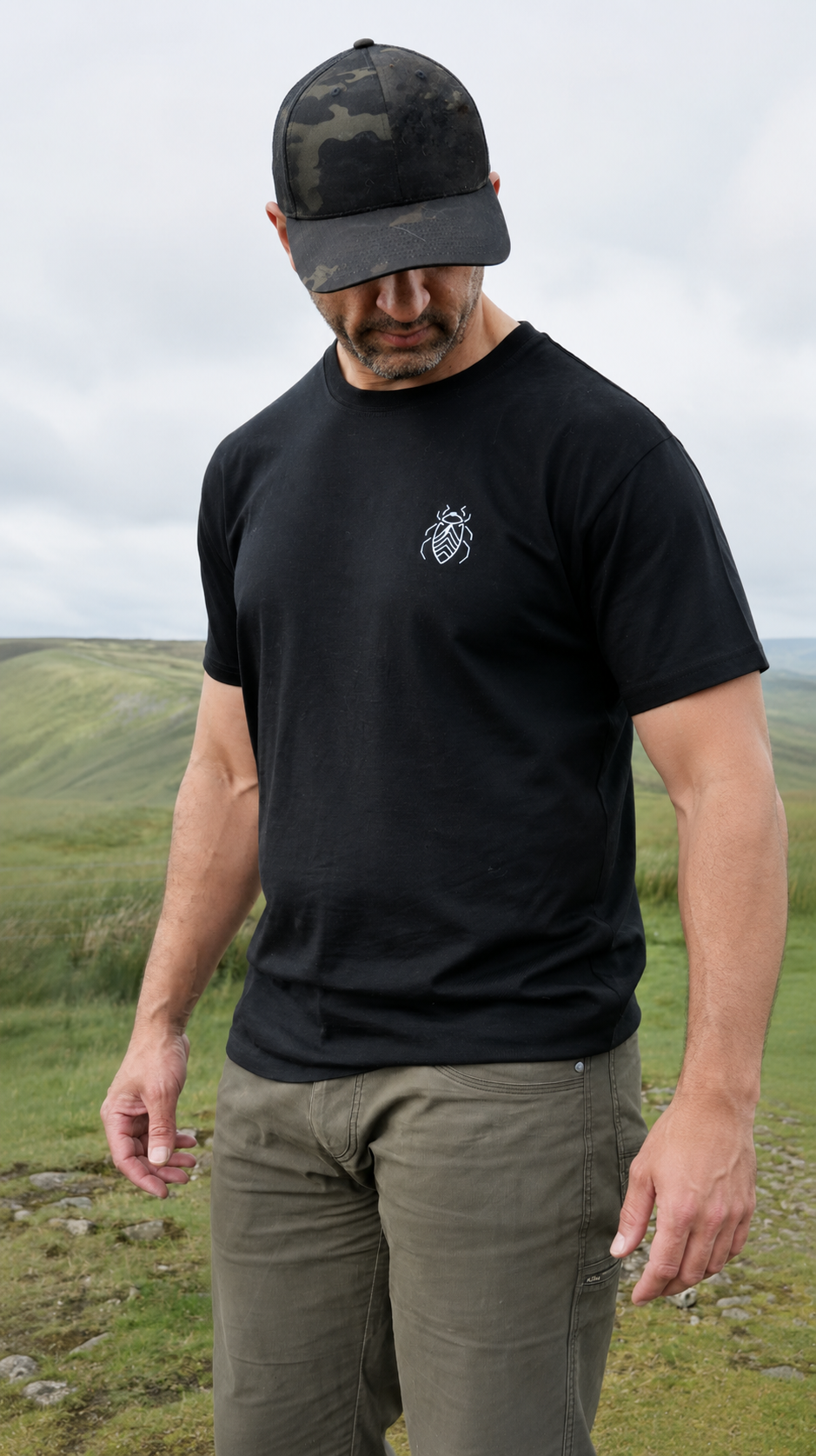 Man wearing the Halfell Origins T-Shirt in black from behind, showing the topographic map print across the back